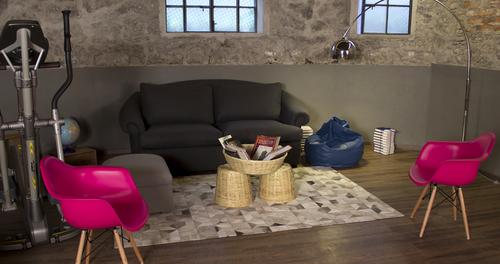 Comfortable sofa and pink chairs with basket table containing magazines
