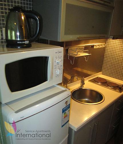 Kitchen with microwave, refrigerator, and kettle