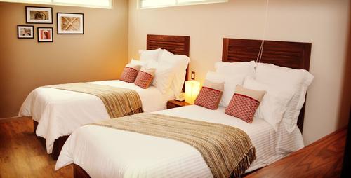 Twin beds with soft pillows, high-quality bedding set, bedside table with telephone and lamp