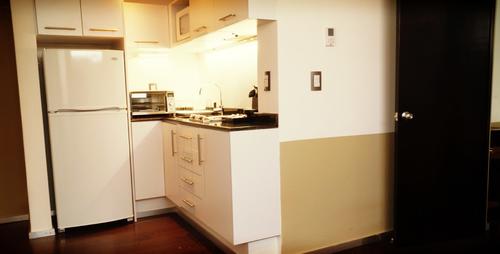 Kitchen with oven, fridge, freezer, microwave, and utensils
