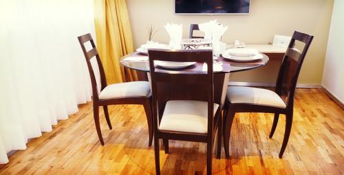 Wooden dining table with four soft, high-quilty chairs
