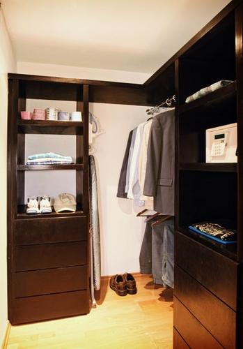 A spacious wardrobe with drawers, safe, ironing board an iron