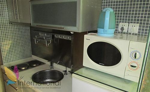 Kitchen with microwave, refrigerator, and kettle