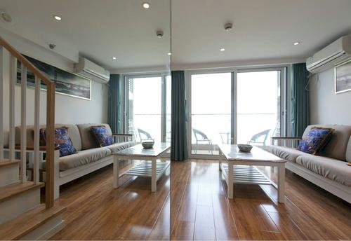 liviningroom with sofa, coffee table, stairs and balconey