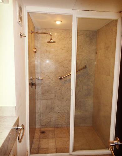 A spacious bathroom with rainforest shower head